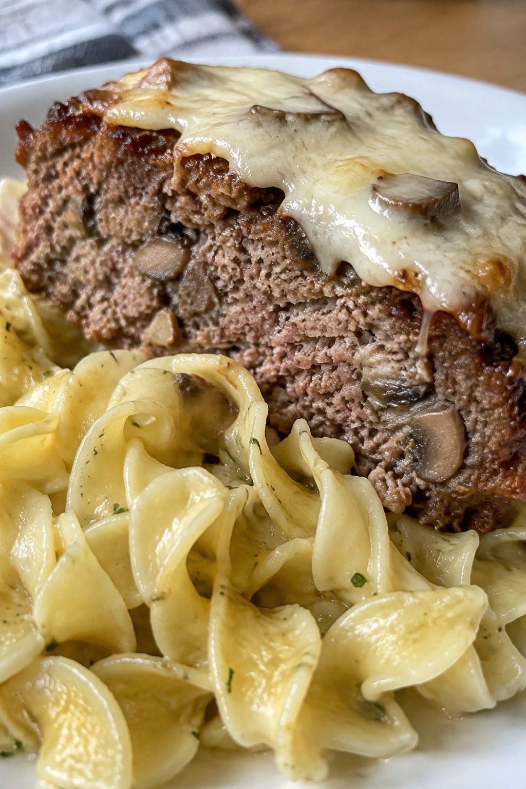Mushroom Swiss Meatloaf Served Over Buttered Egg Noodles